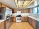 Well-lit kitchen with stainless steel appliances, tile floors, and neutral-toned countertops and wooden cabinets at 5460 Conville Pl, Las Vegas, NV 89120