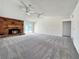 Spacious living room featuring plush carpeting, a brick fireplace, and sliding glass doors for natural light at 5460 Conville Pl, Las Vegas, NV 89120