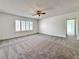 Spacious living room with a ceiling fan, window shutters, and plush carpeting throughout at 5460 Conville Pl, Las Vegas, NV 89120