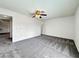 Spacious living room featuring plush gray carpeting, ceiling fan, and neutral color palette at 5460 Conville Pl, Las Vegas, NV 89120