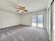 The living room has a sliding glass door, ceiling fan and plush carpeting throughout for a cozy feel at 5460 Conville Pl, Las Vegas, NV 89120
