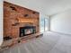 Close-up of a brick fireplace in a spacious living room with sliding glass doors to the backyard at 5460 Conville Pl, Las Vegas, NV 89120