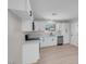 Bright kitchen featuring white cabinets, stainless steel appliances, and laminate flooring at 6181 Cedarwood Ave, Las Vegas, NV 89103