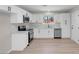 Beautiful kitchen featuring stainless steel appliances, white cabinets, and modern laminate flooring at 6181 Cedarwood Ave, Las Vegas, NV 89103
