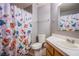 Cozy bathroom with decorative floral shower curtain, white sink, and matching toilet at 6259 Santander Ave, Las Vegas, NV 89103