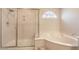 Bright bathroom featuring a glass shower and a luxurious soaking tub with a charming window above at 6559 Musette Ave, Las Vegas, NV 89139