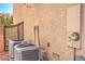 Exterior view of home with central AC units, stucco, and metal gate at 6559 Musette Ave, Las Vegas, NV 89139