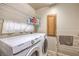 Functional laundry room equipped with a washer, dryer, shelves, and cabinet for storage at 6559 Musette Ave, Las Vegas, NV 89139
