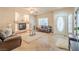 Cozy living room with a fireplace, tile flooring, and ample natural light from the large windows at 6559 Musette Ave, Las Vegas, NV 89139