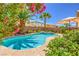 Backyard oasis featuring a sparkling pool, lush landscaping, and a serene outdoor space at 6559 Musette Ave, Las Vegas, NV 89139