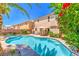 Beautiful backyard oasis with a sparkling pool, hot tub, patio, and lush tropical landscaping at 6559 Musette Ave, Las Vegas, NV 89139