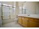 Bathroom with tiled floor, wood vanity, large mirror, and shower/tub combo with glass doors at 66 Sunset Bay St, Las Vegas, NV 89148