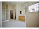 Well-lit bathroom featuring tiled floors, a glass shower, and vanity with large mirror at 66 Sunset Bay St, Las Vegas, NV 89148