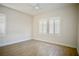 Bright bedroom featuring wood floors, white walls, plantation shutters, and a ceiling fan at 66 Sunset Bay St, Las Vegas, NV 89148