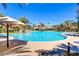 Luxurious resort-style community pool area featuring palm trees, umbrellas, and plenty of seating at 66 Sunset Bay St, Las Vegas, NV 89148