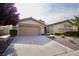 Inviting single-story home with a two-car garage, a driveway, and desert landscaping at 66 Sunset Bay St, Las Vegas, NV 89148