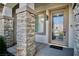 Close-up of the front door, featuring decorative glass and stone pillars, plus a modern exterior light fixture at 66 Sunset Bay St, Las Vegas, NV 89148