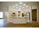 Well-lit kitchen includes an island, granite counters, stainless refrigerator, and light wood cabinets at 66 Sunset Bay St, Las Vegas, NV 89148