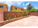 A large brick-paved backyard with retaining walls and varied greenery creates a private outdoor space at 6821 Treble Clef Ave, Las Vegas, NV 89139