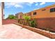 A spacious backyard area with a brick retaining wall offers an outdoor oasis with some greenery at 6821 Treble Clef Ave, Las Vegas, NV 89139