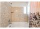 Bathroom with a bathtub and a shower with stone-patterned walls at 6821 Treble Clef Ave, Las Vegas, NV 89139