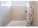 Bathroom with a bathtub and a shower with stone-patterned walls and floral curtain at 6821 Treble Clef Ave, Las Vegas, NV 89139