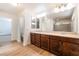 Bathroom featuring double sinks, granite counters, wood cabinets, and glass-enclosed shower at 6821 Treble Clef Ave, Las Vegas, NV 89139