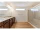 Bathroom featuring double sinks, wood cabinets, and a glass-enclosed shower at 6821 Treble Clef Ave, Las Vegas, NV 89139