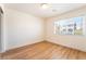 Bedroom with wood-look floors, neutral walls, and a window with neighborhood views at 6821 Treble Clef Ave, Las Vegas, NV 89139