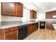 The kitchen has stainless steel appliances, wood cabinets, granite countertops, and wood floors at 6821 Treble Clef Ave, Las Vegas, NV 89139