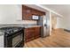Kitchen with wood cabinets, granite countertops, and stainless steel refrigerator and microwave at 6821 Treble Clef Ave, Las Vegas, NV 89139