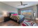 Stylish bedroom featuring hardwood floors, a ceiling fan, and a large window for natural light at 6837 Dragonfly Rock St, Las Vegas, NV 89148