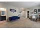 Comfortable bonus room featuring a blue sofa, desk, and access to a bathroom and hallway at 6837 Dragonfly Rock St, Las Vegas, NV 89148