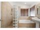 Bathroom featuring tub with glass block wall and pedestal sink at 688 Arrowhead Canyon Dr, Henderson, NV 89002