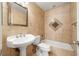 Cozy bathroom featuring a pedestal sink and a tub with tiled walls and decorative accents at 688 Arrowhead Canyon Dr, Henderson, NV 89002