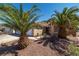 Attractive single-story home featuring desert landscaping and mature palm trees at 688 Arrowhead Canyon Dr, Henderson, NV 89002