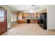 Bright kitchen featuring oak cabinets, black appliances, tile flooring, and large windows at 688 Arrowhead Canyon Dr, Henderson, NV 89002