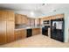 Well-lit kitchen with tile flooring, stainless steel appliances, and wooden cabinets at 688 Arrowhead Canyon Dr, Henderson, NV 89002