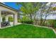 View of the backyard and patio with outdoor dining, landscaping, and mature trees at 729 Sir James Bridge Way, Las Vegas, NV 89145