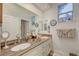 Well lit bathroom with double vanity, granite counters, mirrors, decor and a large window allowing in natural light at 729 Sir James Bridge Way, Las Vegas, NV 89145
