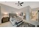 Large bedroom with king bed, ceiling fan, rug, bedside tables, and artwork on the walls at 729 Sir James Bridge Way, Las Vegas, NV 89145
