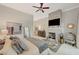 Spacious bedroom with king bed, ceiling fan, fireplace, rug and doorway leading to en-suite bathroom at 729 Sir James Bridge Way, Las Vegas, NV 89145