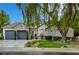 Charming single-story home featuring a stone facade, well-manicured lawn, and a three-car garage at 729 Sir James Bridge Way, Las Vegas, NV 89145