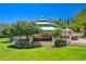 Charming gazebo nestled in a manicured green space, featuring stone accents, white railings, and a tiered roof at 729 Sir James Bridge Way, Las Vegas, NV 89145