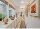 Hallway featuring tile floors, lots of natural light from the windows, custom cabinets, and artwork on the walls at 729 Sir James Bridge Way, Las Vegas, NV 89145