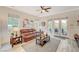 Cozy living room features a comfortable leather sofa, ceiling fan, and direct access to the outdoor patio through French doors at 729 Sir James Bridge Way, Las Vegas, NV 89145