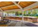 Outdoor kitchen featuring multiple stainless steel grills, brick counters, and a wooden ceiling over a brick-paved area at 729 Sir James Bridge Way, Las Vegas, NV 89145