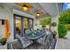 Covered patio with dining set, ceiling fans, and views of backyard greenery at 729 Sir James Bridge Way, Las Vegas, NV 89145