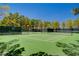 View of the neighborhood tennis court with manicured landscaping and shade at 729 Sir James Bridge Way, Las Vegas, NV 89145