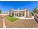 An appealing backyard, featuring an airy covered patio, manicured lawn, and gravel landscaping at 7410 Bridlehorne Ave, Las Vegas, NV 89131